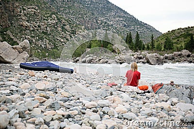 A man yogi sits on rocks in the mountains Stock Photo