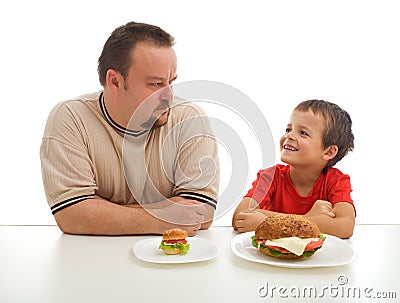 Man and young boy rival over food Stock Photo