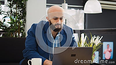 Manager comparing data on laptop Stock Photo