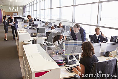 Manager in discussion with coworker in an open plan office Stock Photo