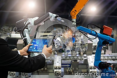 Manager engineer touch screen control automation robot arms the production of factory parts engine manufacturing industry robots a Stock Photo