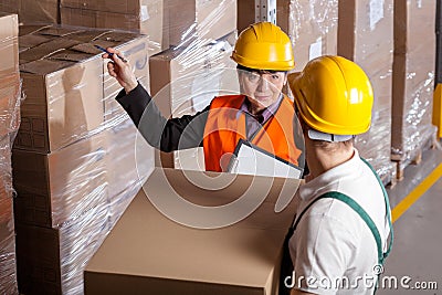 Manager giving worker instruction in warehouse Stock Photo