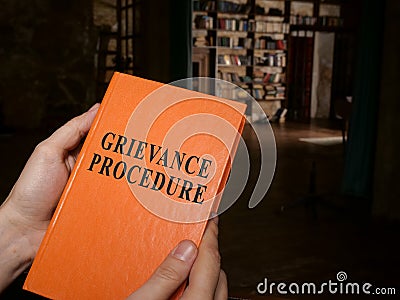 Manager holds guide about grievance procedure. Stock Photo