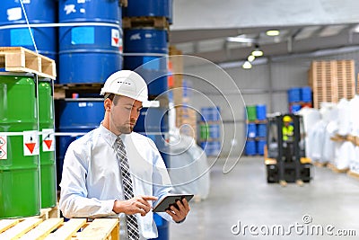 Manager in a logistic company work in a warehouse with chemicals Stock Photo