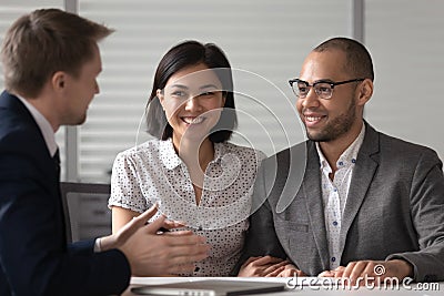 Manager realtor banker consulting happy diverse young couple at meeting Stock Photo