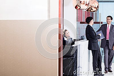 Manager welcoming business associate in office lounge Stock Photo