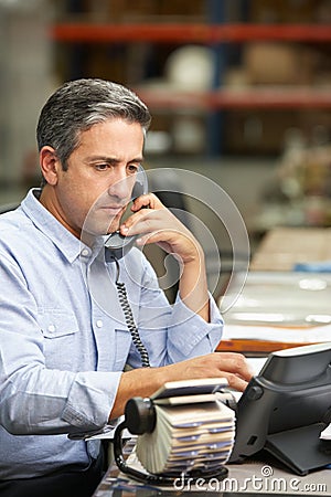 Manager Working At Desk In Warehouse Stock Photo