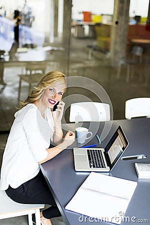 Manageress with mobile phone in office Stock Photo