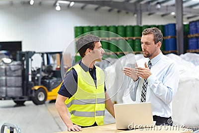 managers and workers in the logistics industry talk about working with chemicals in the warehouse Stock Photo