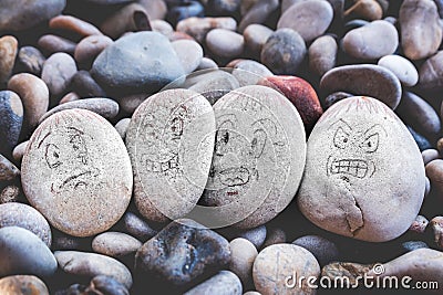 Managing emotions emoji faces on stones - sad, happy, surprised worried and angry feelings draw Stock Photo