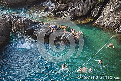 Manarola ITALY - 2 August 2023 - Blurred drops of water with people climbing from the rock Editorial Stock Photo