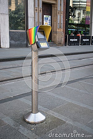 Ticket purchase validation point machine on metal pole on pavement for public transport. Pride rainbow symbol on top Editorial Stock Photo