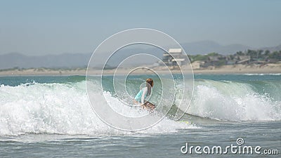 Young woman on surfboard sliding on the waves on a clear day Editorial Stock Photo