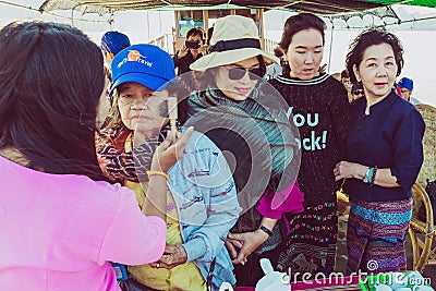 MANDALAY-Myanmar, January 20, 2019 : Female tourist guide paints tanaka powder on female tourist face while traveling on boat on Editorial Stock Photo