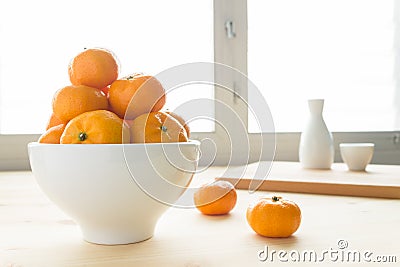 Mandarin or China Orange in White Bowl on Wood Table and Tea Cup Stock Photo