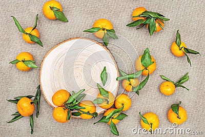 Mandarin oranges with leaves on rustic background. Citrus fruits on wood plank Stock Photo