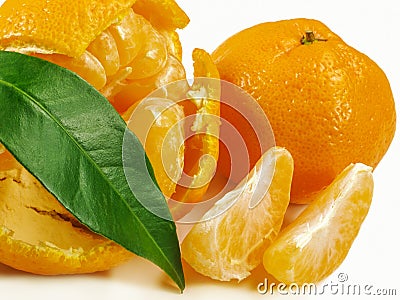 Mandarin, peeled mandarin with slices and green leaf. Stock Photo