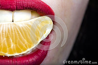 Mandarin slice in mouth in girl`s mouth close-up Stock Photo