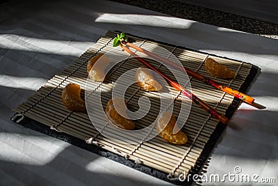 Mandarin or tangerine with chopsticks as sushi Stock Photo