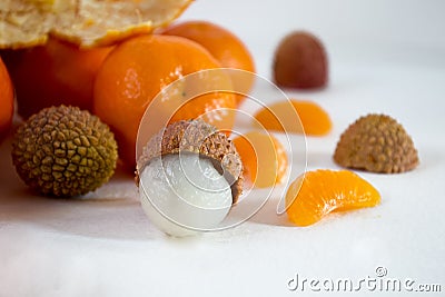 Mandarins on a white background with lobule, peel, citron and litchi. Side view, close. Citrus reticulata. Litchi chinensis Stock Photo