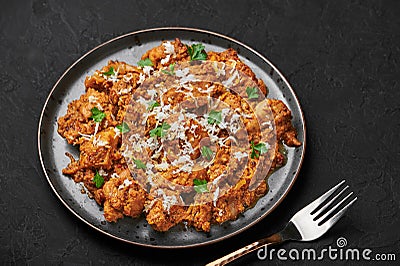 Mangalorean Chicken Sukka on black plate on dark slate table top. Indian cuisine coconut curry dish. Asian food and meal Stock Photo