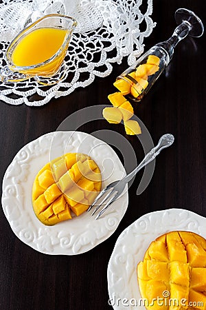 Mango fruit cubes and mango juice puree on dark wooden background. Stock Photo