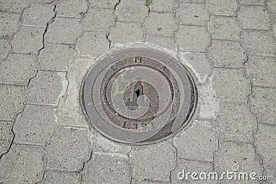 manhole cover on concrete sidewalk, neighborhood near the equator line in a park near Quito Editorial Stock Photo