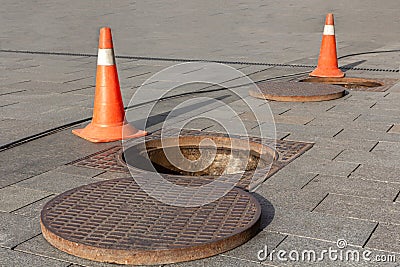 Manhole cover open in street and repair of roads. Accident with sewer hatch in city. Concept of repair of sewage, underground Stock Photo