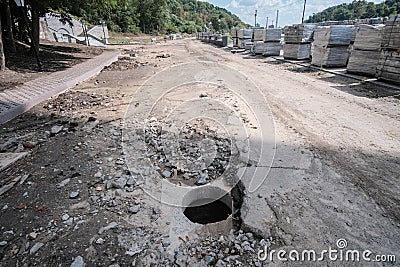 Manhole near reconstruction road without signs. Open sewer Stock Photo