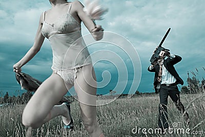 Maniac chasing with chainsaw Stock Photo