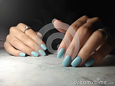 Manicure with a glossy blue solid coating. Stock Photo