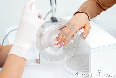 Manicure master hands spraying nails Stock Photo