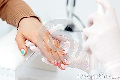 Manicure master hands spraying nails Stock Photo