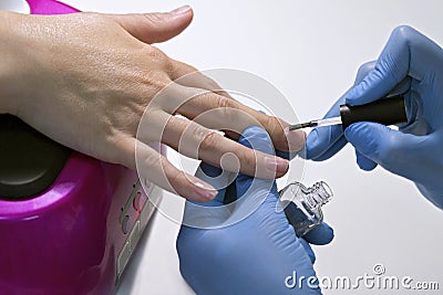 Manicure. Master make Manicure. Apply varnish to the nails. Beauty and fashion concept. Stock Photo