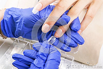 Manicure specialist care by finger nail in beauty salon. Stock Photo