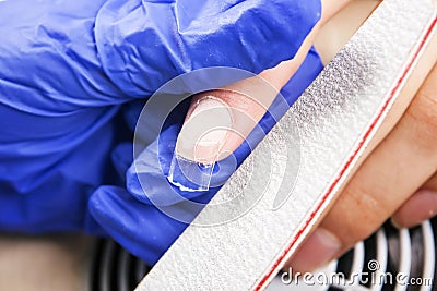 Manicure specialist care by finger nail in beauty salon. Stock Photo