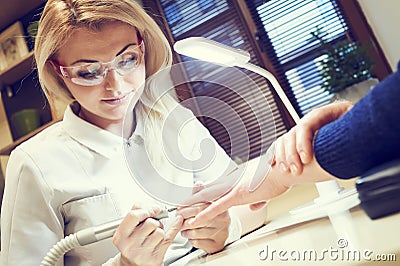 Manicure specialist woman doing mail finger nail care Stock Photo