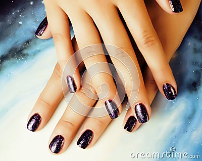 manicure stylish concept: woman fingers with nails purple glitter on nails like cosmos, universe background Stock Photo