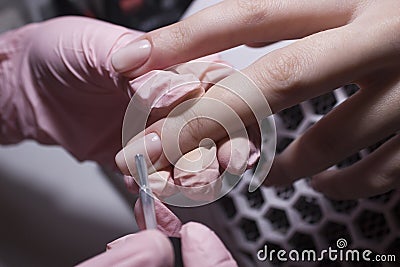 The manicurist applies a layer of gel Polish to the client`s nail. Stock Photo