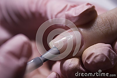The manicurist applies a layer of gel Polish to the client`s nail. Applying pink nail Polish with a brush. Stock Photo