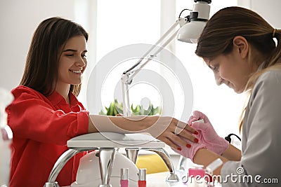 Manicurist applying polish on client`s nails in beauty salon Stock Photo