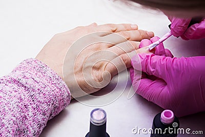 The manicurist covers the nails with varnish. Stock Photo