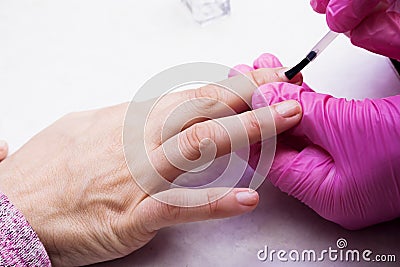 The manicurist covers the nails with varnish. Stock Photo