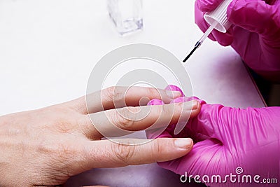 The manicurist covers the nails with varnish. Stock Photo