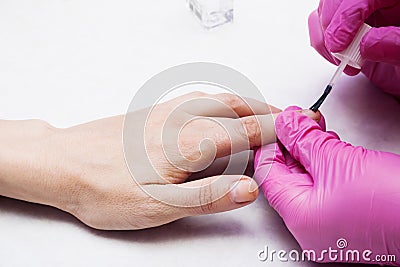 The manicurist covers the nails with varnish. Stock Photo