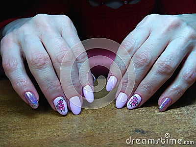 The manicurist excellently made her work a beautiful manicure with a polish gel on her hands and the client is happy Stock Photo