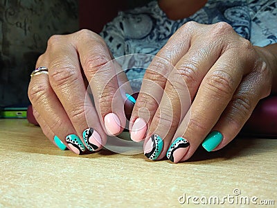 The manicurist excellently made her work a beautiful manicure with a polish gel on her hands and the client is happy Stock Photo