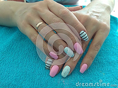 The manicurist excellently made her work a beautiful manicure with a polish gel on her hands and the client is happy Stock Photo