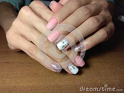 The manicurist excellently made her work a beautiful manicure with a polish gel on her hands and the client is happy Stock Photo