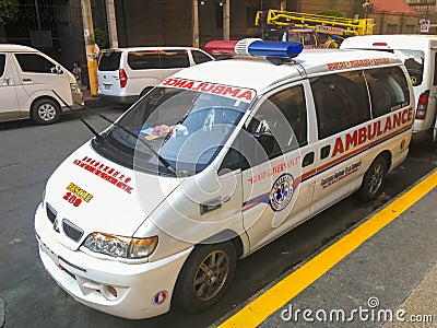 An ambulance is parked near the sidewalk Editorial Stock Photo